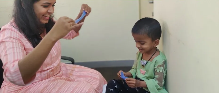 A therapist following a child’s lead while playing with toys