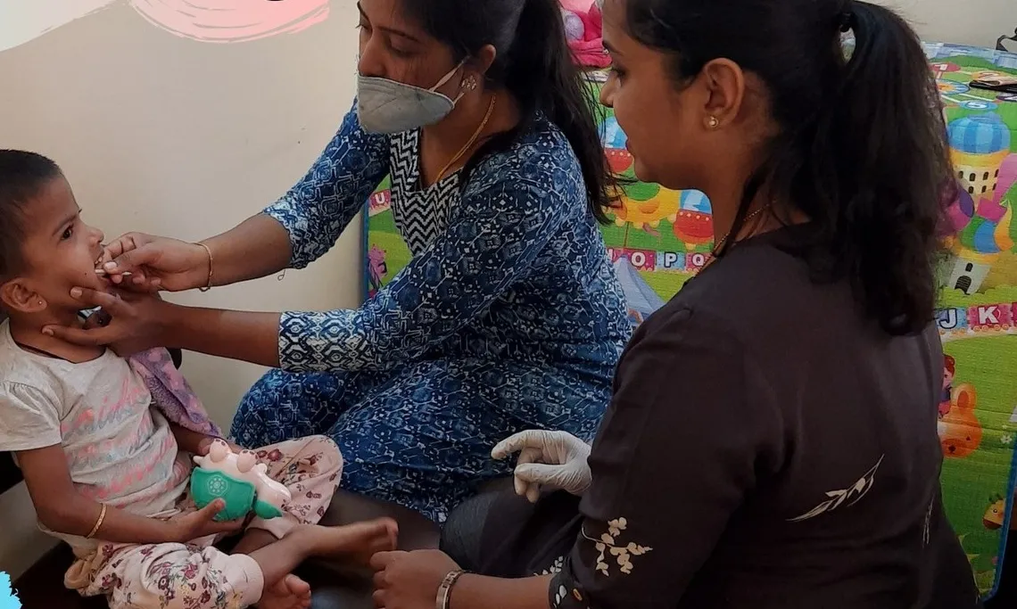 A parent learning a technique from a therapist during her child’s session