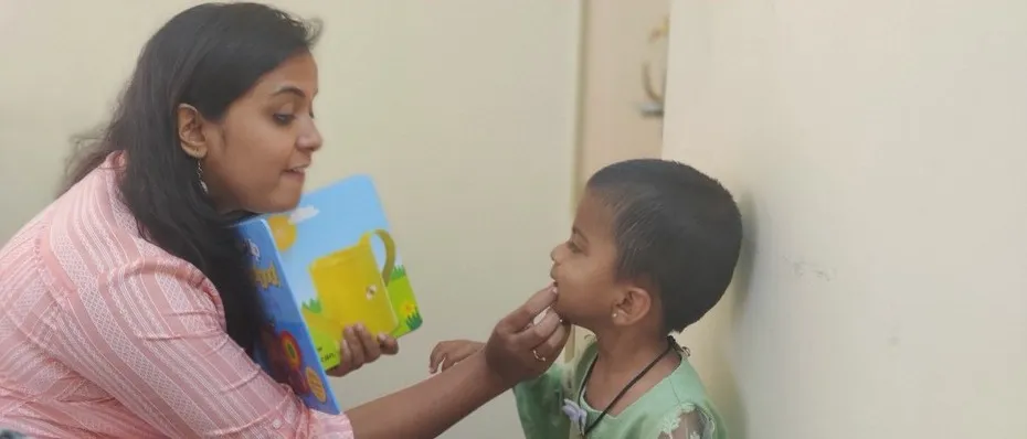 A therapist using touch cues to help a boy form a sound
